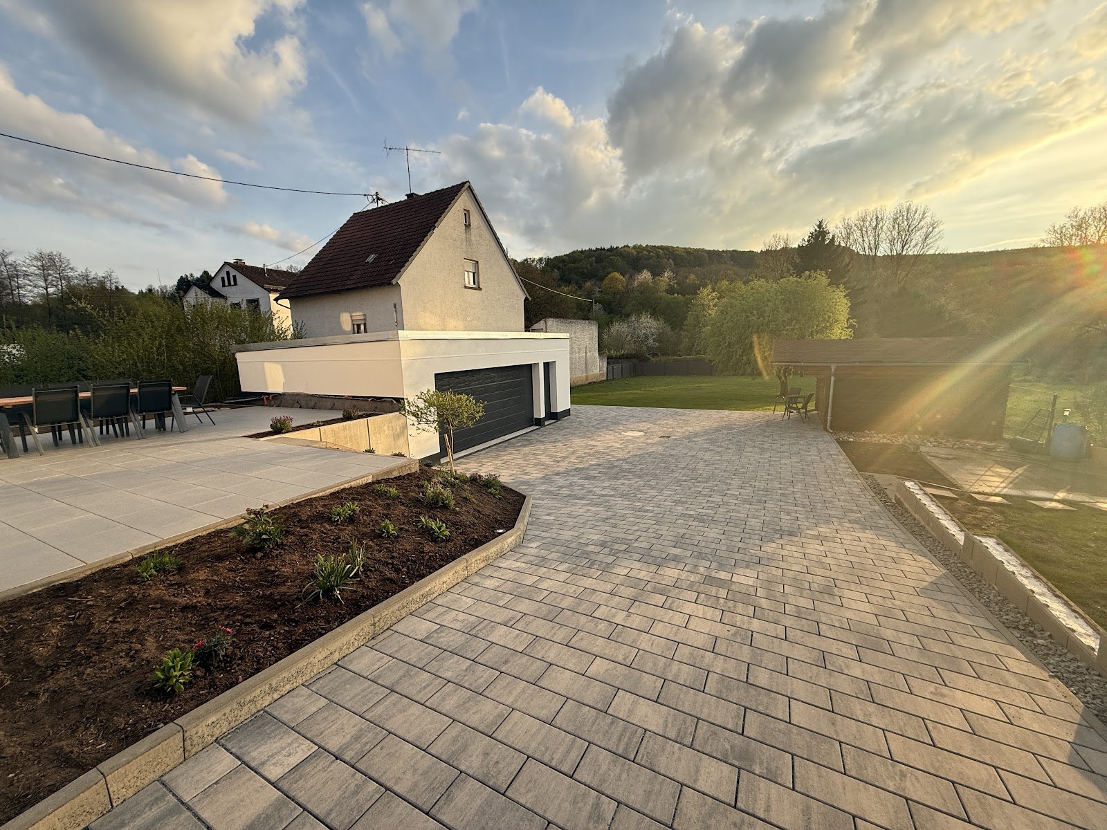 Fertig gepflasterter Hof mit Plattenterrasse und Randeinfassung